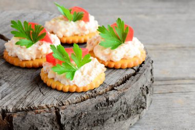 Baharatlı peynir, kraker üzerinden pişmiş kanepe domates dilim ve maydanoz yaprağı. Baharatlı peynir kanepe vintage ahşap arka plan üzerinde. Hızlı meze tarifi