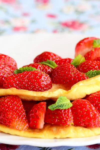 Süßes Omelett gefüllt mit frischen Erdbeeren auf einem weißen Teller. leckere und flauschige Omelett-Idee. Frühstück Rezept. vertikales Foto. Nahaufnahme — Stockfoto