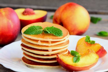 Şurubu ve beyaz bir plaka üzerinde ızgara nektarin krep yığını. Kolay tatlı krep tarifi. Lezzetli kahvaltı veya brunch çocuklar ve bütün aile için. Portre