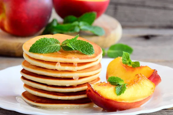 Pfannkuchen mit Sirup und gegrilltem Obst auf einem Teller. Frühstück Pfannkuchen Rezept für Kinder. Nahaufnahme — Stockfoto