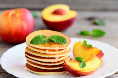 Ev yapımı kek sirup, nektarin ve nane bir plaka üzerinde. Kahvaltı için kolay temel krep. Portre