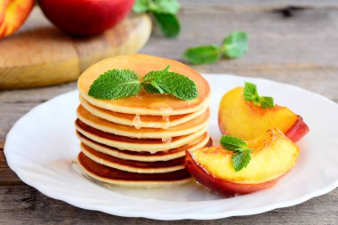 Tatlı yığını şurubu ve ızgara nektarin ile servis tabağı dilimleri krep. Basit krep tarifi. Lezzetli kahvaltı veya brunch çocuklar ve bütün aile için. Portre