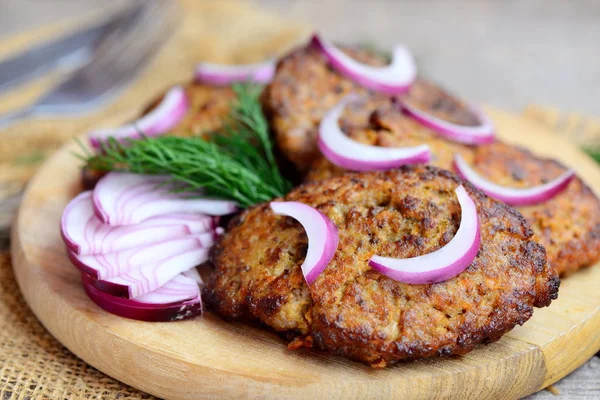 Tasty chicken liver cutlets with vegetables. Roasted chicken liver cutlets on a wooden board. Healthy eating. Rustic style. Closeup