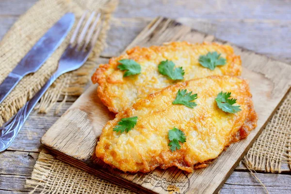 Gebratene Hühnerbrust auf einem Schneidebrett und einem alten Holztisch. schnell und einfach Hühnerbrust Rezept für das Abendessen. rustikaler Stil — Stockfoto