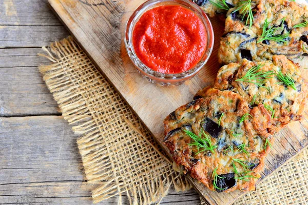 Hamburger di melanzane croccanti con aglio e aneto su una tavola di legno. Salsa di pomodoro in una ciotola di vetro. Ricetta hamburger di melanzane vegane — Foto Stock