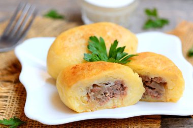 Doldurma beyaz bir tabak ve vintage ahşap bir masa üzerinde bir etli patates zrazy. Geleneksel Ukrayna zrazy tarifi. Portre