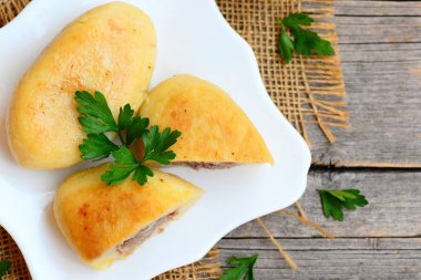 Beyaz bir tabak ve vintage ahşap bir masa bir etli patates zrazy doldurulmuş. Kolay zrazy tarifi. Portre. Üstten Görünüm