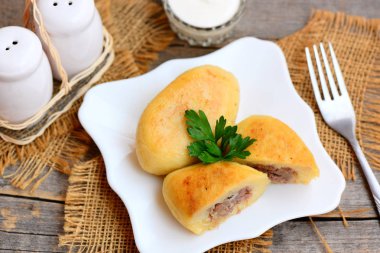 Kızarmış baharatlı et ve patates köftesi beyaz tabakta. Patates köftesi zemin sığır eti tarifi ile doldurulmuş. Rustik tarzı. Portre