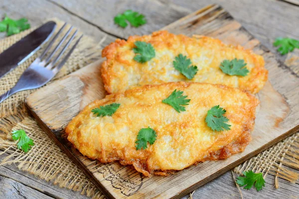 Kızarmış tavuk fileto kesme tahtası ve eski bir ahşap masa. Çabuk ve sade tavuk fileto tarifi akşam yemeği için. Rustik tarzı