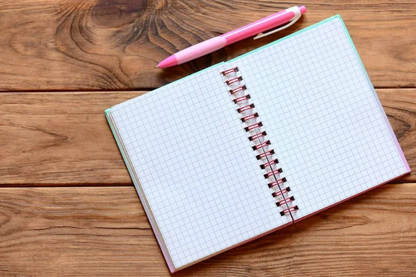 Open notebook for writing notes, pen on a wooden table. Blank notebook pages for input the text. Closeup. Top view — Stock Photo, Image