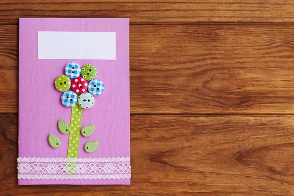 Mother's day or birthday greeting card with flower isolated on a wooden background with copy space for text. Simple handmade card to make in school or at home. Paper crafts for kids. Closeup. Top view — Stock Photo, Image