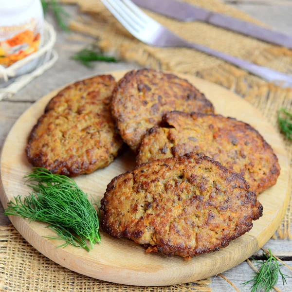 Kızarmış pirzola tavuk karaciğer yapılan kıyma, havuç ve soğan. Ahşap kesme tahtası üzerinde hızlı kolay karaciğer pirzola. Portre