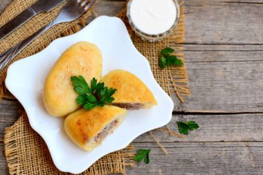 Bir servis tabağı ve kopya alanı metin için bir vintage ahşap arka plan doldurarak bir etli ev patates zrazy. Ukrayna, Rusya veya Beyaz Rusça geleneksel çanak