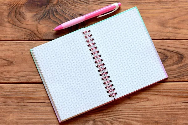 Caderno de papel aberto em branco para escrever notas, caneta na mesa de madeira. Planilha de caderno de papel com lugar vazio para texto. Fecha a porta. Vista superior — Fotografia de Stock