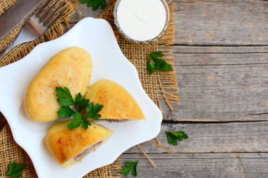 Kavrulmuş toprak zrazy bir servis tabağı üzerinde biftek ve patates. Çatal, ekşi krema sosu bir cam kase kopya alanı metin için ahşap bir zemin üzerine. Rustik tarzı. Portre