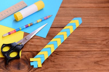 Çocuklar ile metin için boş yer yer işareti kahverengi ahşap arka plan üzerinde kağıt. Kağıt katlama ile çocuklar için kağıt zanaat. İleti örneği üzerinde ahşap bir masa ayarla. Üstten Görünüm