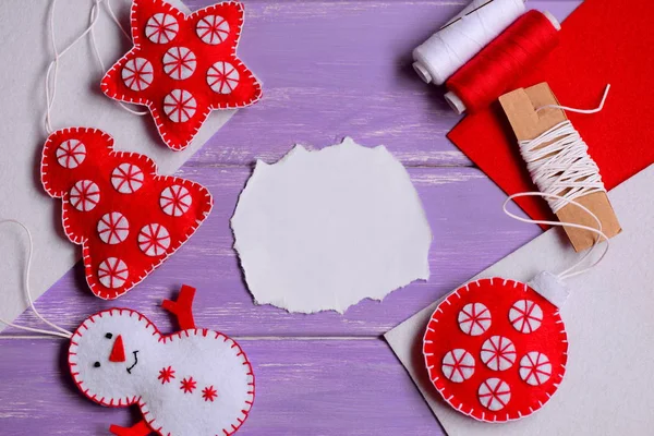 Vilt Christmas crafts patronen. Vilten sterren, kerstboom, sneeuwpop en bal op een paarse houten achtergrond met kopie ruimte voor tekst. Handwerk benodigdheden. Gelukkig Kerstmis samenstelling of kaart. Bovenaanzicht — Stockfoto