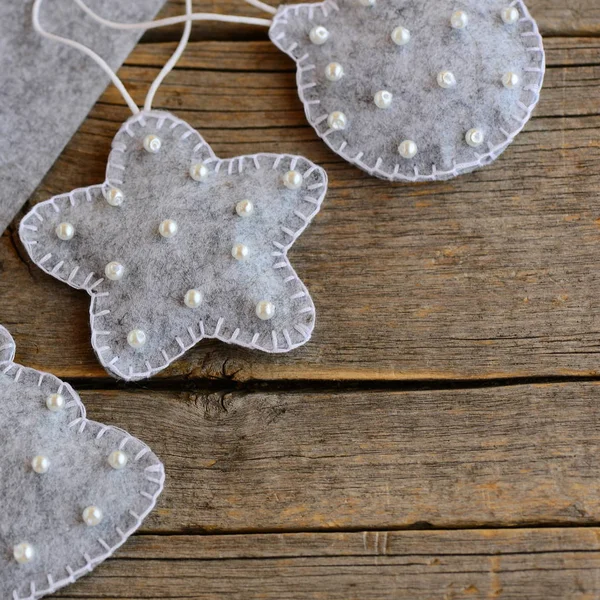 Feltro ornamenti di Natale per fare. Giocattoli dell'albero di Natale fatti di feltro e decorati con perline. Sfondo in legno vintage con spazio copia per il testo. Artigianato natalizio fatto in casa per bambini. Primo piano — Foto Stock