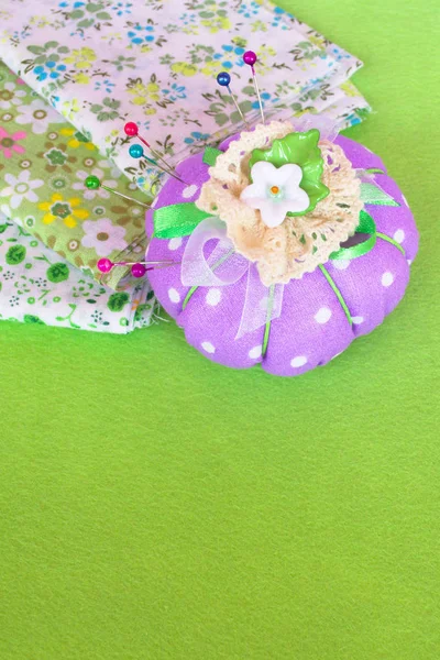 De pin-kussen met stukken van de doek op de groene vilt — Stockfoto