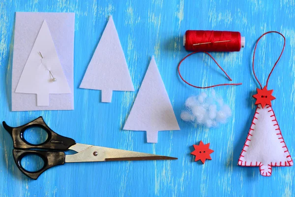 Handmade felt Christmas tree, paper template, felt details, thread, needle, pin, scissors on a wooden background. Set for creating a Christmas ornament. Sewing design set for kids. Tutorial. Top view — Stock Photo, Image