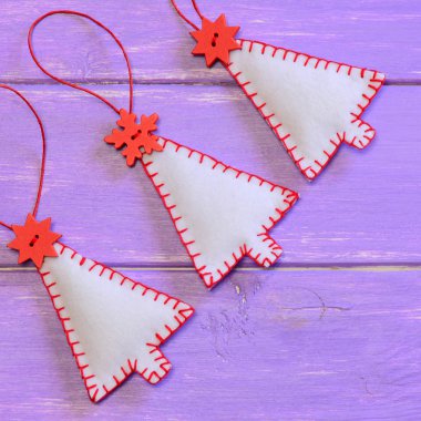 Noel süsler mor ahşap arka plan ağaç. El yapımı süsler hissettim. Noel dikiş projeler. Noel duvar dekorasyon ev yapımı fikir. Portre