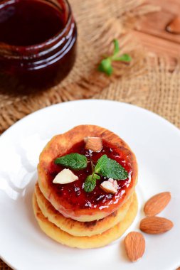 Küçük syrniki. Berry reçel ve beyaz tabakta badem Fried lor krep. Rus krep tarifi. Sağlıklı kahvaltı fikir 