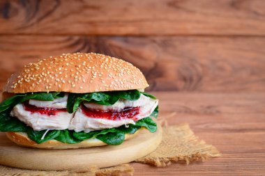 Ev yapımı tavuk göğsü hamburger. Lezzetli tavuk burger taze ıspanak ve berry jam ahşap bir gemide. Ahşap arka plan kopya alanı ile