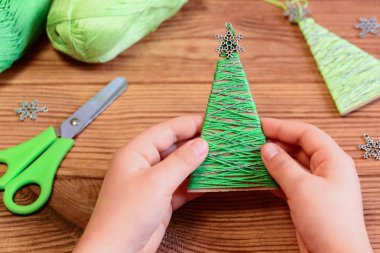 Çocuk bir Noel ağacı süsle elinde tutuyor. Çocuk bir Noel ağacı süsle gösteriyor. Kolay geri dönüşümlü el sanatları. Mery Christmas. Noel ağacı dekor. Noel kartı. Noel dekorasyonu. Tatil arka plan. Noel süsler. 