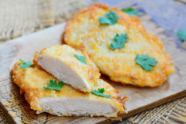 Kızarmış tavuk göğsü kesme tahtası ve eski bir ahşap masa tava. Ev yapımı tavuk göğsü tarifi akşam yemeği ya da öğle yemeği için. Rustik tarzı. Portre. Tavuk biftek tarifi Pakistan. Tavuk kızarmış biftek meyilli