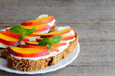 Yoğurt peynir, taze kuru soğan dilimleri ve nane ile hızlı sandviç. Vejetaryen sandviç yoğurt peynir bir servis tabağı ve kopya alanı ile bir vintage ahşap arka plan ile. Portre. Yoğurt peynirli sandviç. En iyi sandviç tarifi