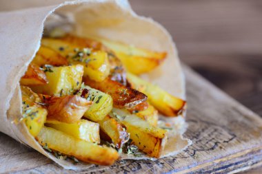 Ev yapımı baharatlı patates kağıt ve tahta bir gemide. Patates tarifi akşam yemeği ya da öğle yemeği için. Portre