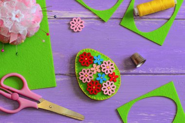 Paskalya yortusu yumurta dekor hissettim. Paskalya yortusu yumurta dekor ahşap çiçek düğmeleri ile hissettim. Hissettim hurda, makas, yüksük, iplik, ahşap arka plan üzerinde iğne. DIY Paskalya dekorasyon. Kolay Paskalya el sanatları. Paskalya zanaat fikir. Kolay Paskalya el sanatları. Paskalya DIY süslemeleri