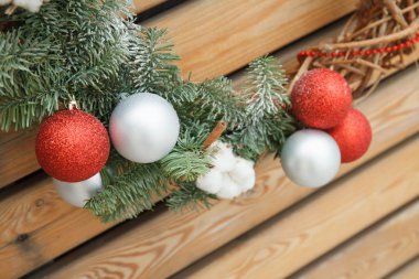 Noel, xmas, yeni yıl kırmızı ve beyaz, topları, çelenkleri ve pamuğu olan gümüş kürk ağacı süsü, ahşap arka planda sarmaşık