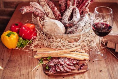 Ahşap bir masa üzerinde kırmızı şarap ile İtalyan sosis