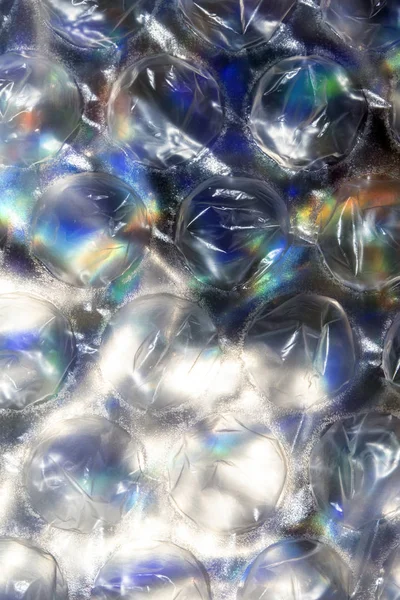 Close Up of Round Bubble Wrap on Top of Shiny Paper to Make an Abstract Background