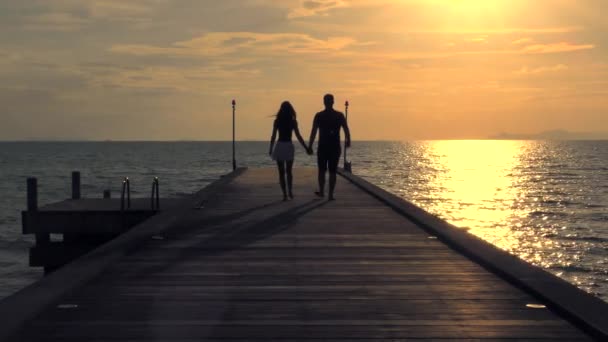 Coulpe romántico caminando en la playa al atardecer — Vídeos de Stock