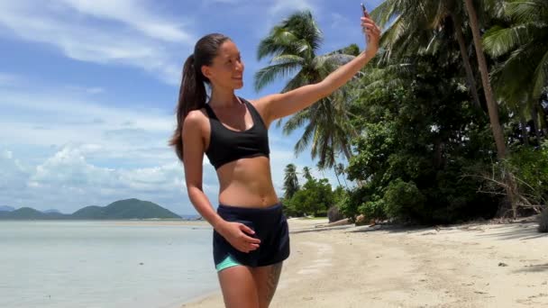 Hermosa joven mujer hace selfie en un paraíso tropical playa fondo — Vídeo de stock