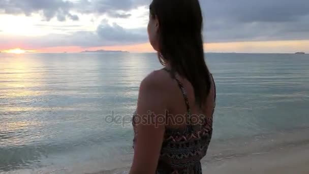 Hermosa mujer disfrutando de la puesta de sol en la playa — Vídeos de Stock