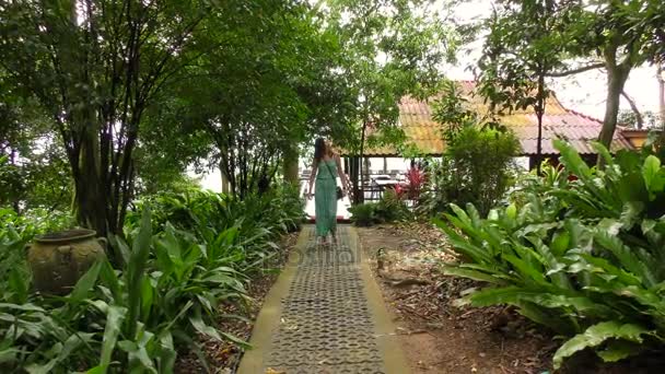美しいアジアの女性旅行者歩行パスに沿ってジャングルの中で — ストック動画