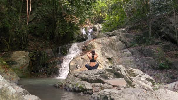 若い女性が滝で瞑想します。 — ストック動画