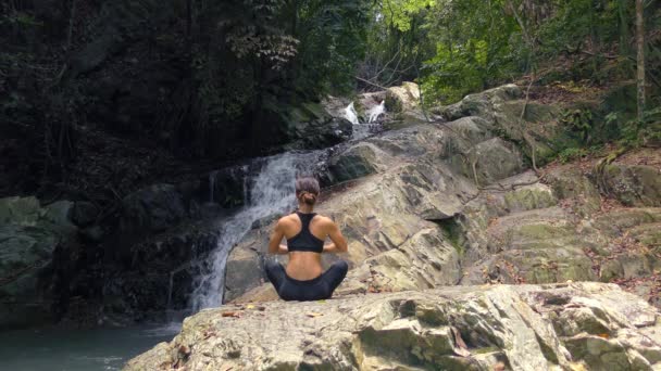 Giovane donna medita alla cascata — Video Stock