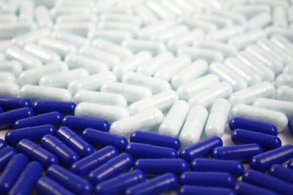 Many pills and tablets in blue and white color. Pharmacy medical background. Close up of a lot of drugs. Pharmacological industry topic. — Stock Photo, Image