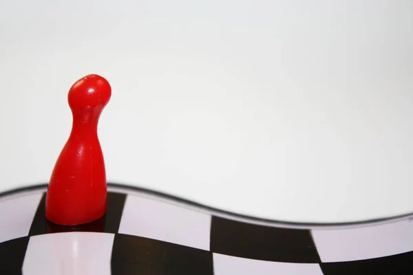 Deformované abstraktní zářivě červená ludo kus na křivky šachovnici s prázdnou bílým pozadím — Stock fotografie