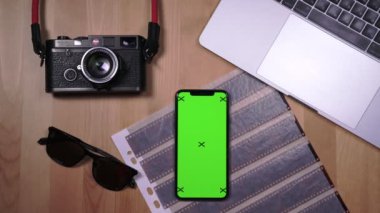 Masaüstü arka planında bir kitap ve kamera ile akıllı telefon