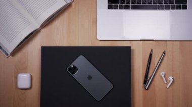 Masaüstü arka planında bir kitap ve kamera ile akıllı telefon