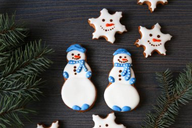 Xmas gingerbread çerezleri kardan adam ve koyu ahşap arka plan dallarda köknar ile kar taneleri şeklinde. 