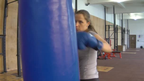 Bolso de boxeo de entrenamiento de mujer de kickboxing de cámara lenta en Fitness Studio — Vídeos de Stock