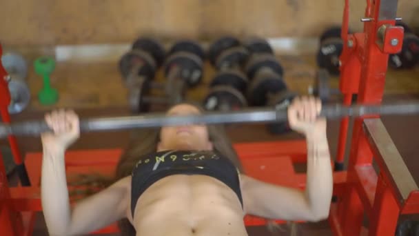 Attraktiva kvinnliga idrottare gör Barbell bänkpress i gymmet — Stockvideo