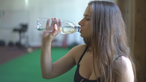 Frau in Turnhalle trinkt Wasser — Stockvideo