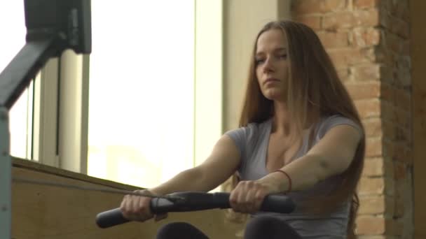 慢运动女人上划船机在健身房锻炼 — 图库视频影像